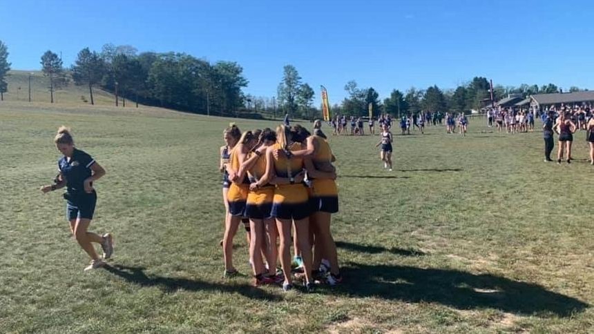 women's cross country team in a huddle 