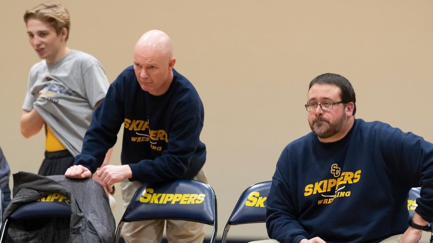 Jason Klink (right), Head Wrestling Coach, watches the team at a home dual meet.