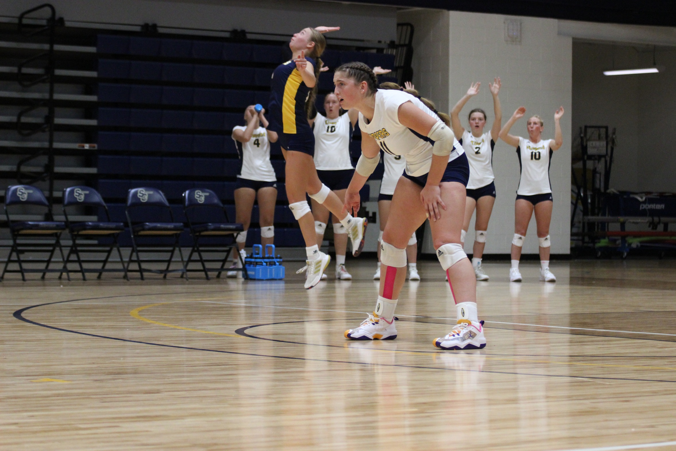 #8 Rachel Dunavant serves ball while #11 Piper Clark waits for the return 