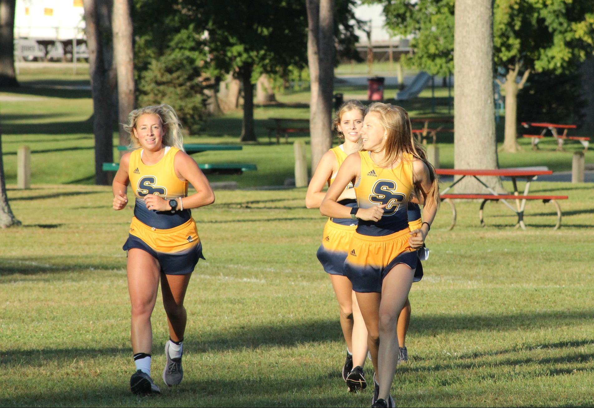 3 sc4 cross country runners running in a pack 